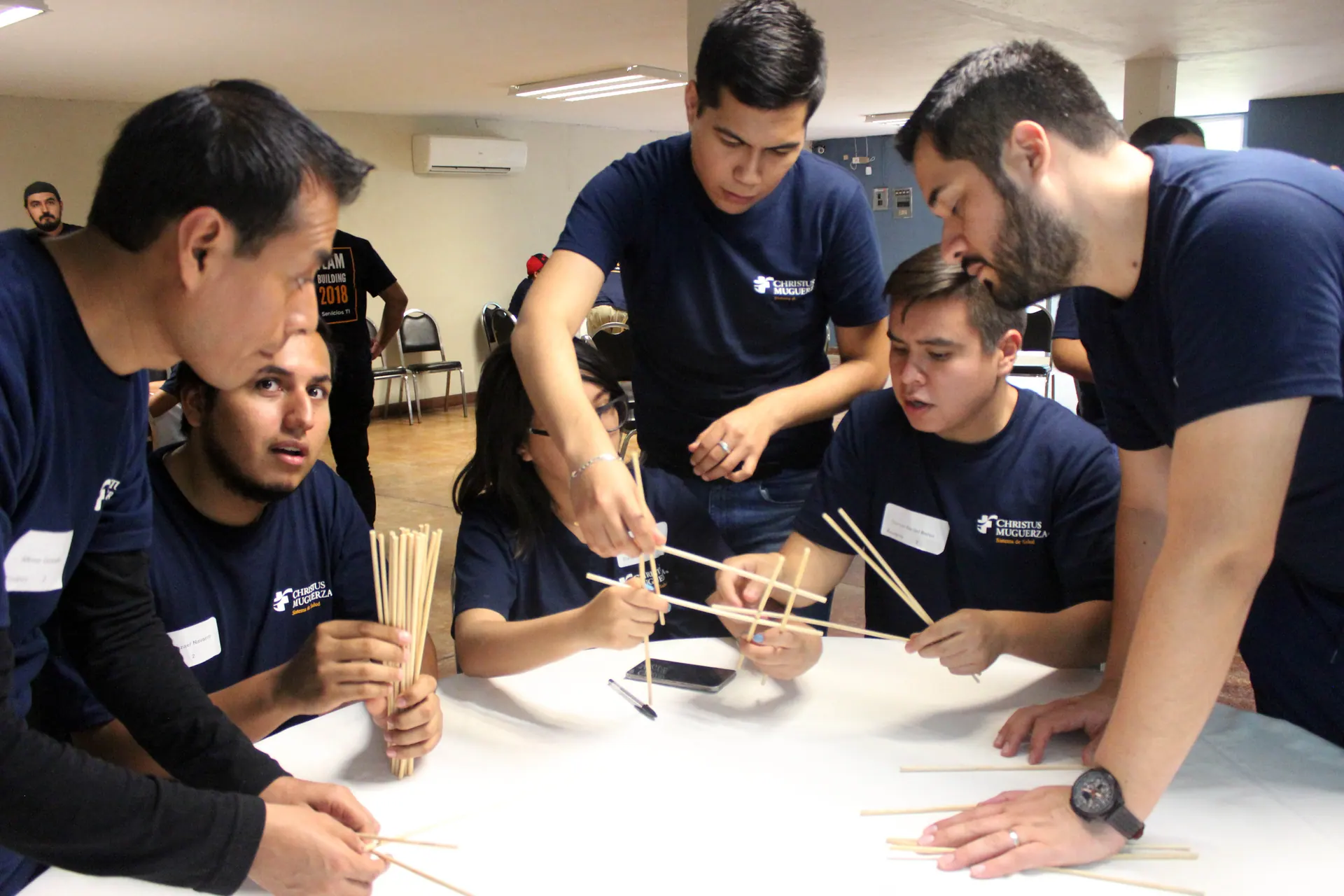 Miembros del equipo de ALYAX trabajando juntos en un proyecto creativo en interiores, resolviendo un reto de manera colaborativa