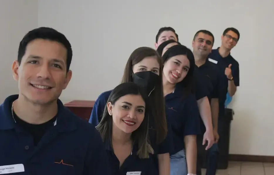Grupo de profesionales de ALYAX posando juntos con uniformes azules, reflejando confianza, profesionalismo y unidad