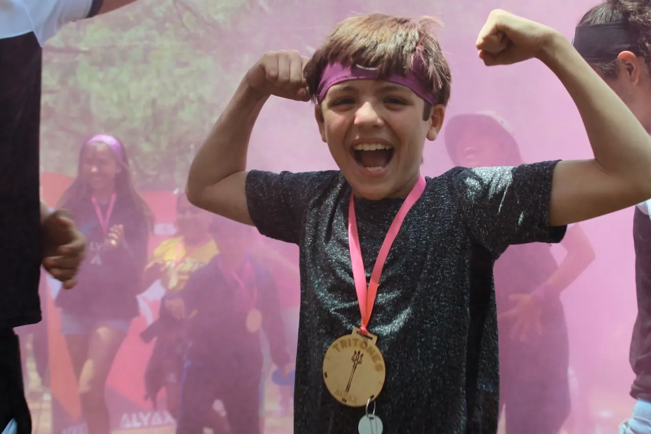 Campista con medalla presume los brazos entre humo rosa