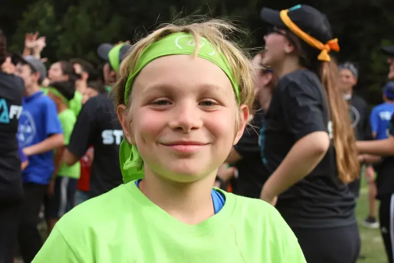 Niño con banda verde en la cabeza sonriendo