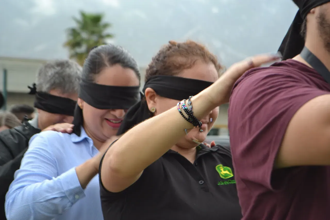 Ejercicio grupal donde los participantes trabajan con los ojos vendados, promoviendo confianza y coordinación en equipos de trabajo