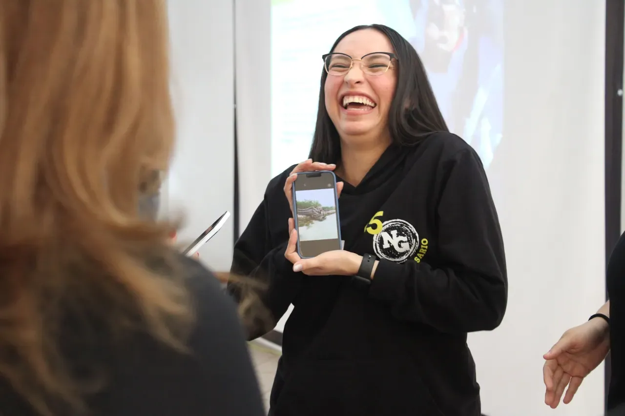 Mujer riendo durante una sesión interactiva, destacando el aprendizaje dinámico y motivador del curso