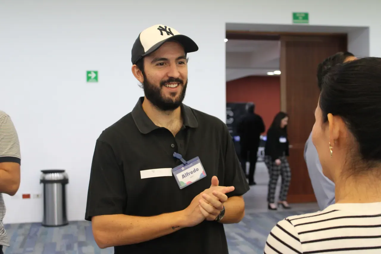 Joven sonriente durante una actividad, mostrando la confianza y camaradería que se desarrolla en el trabajo en equipo