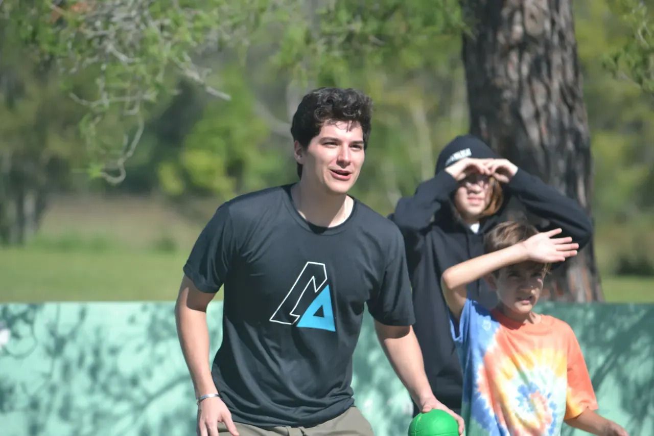 Joven participando en una actividad grupal al aire libre, mostrando energía y motivación durante la integración