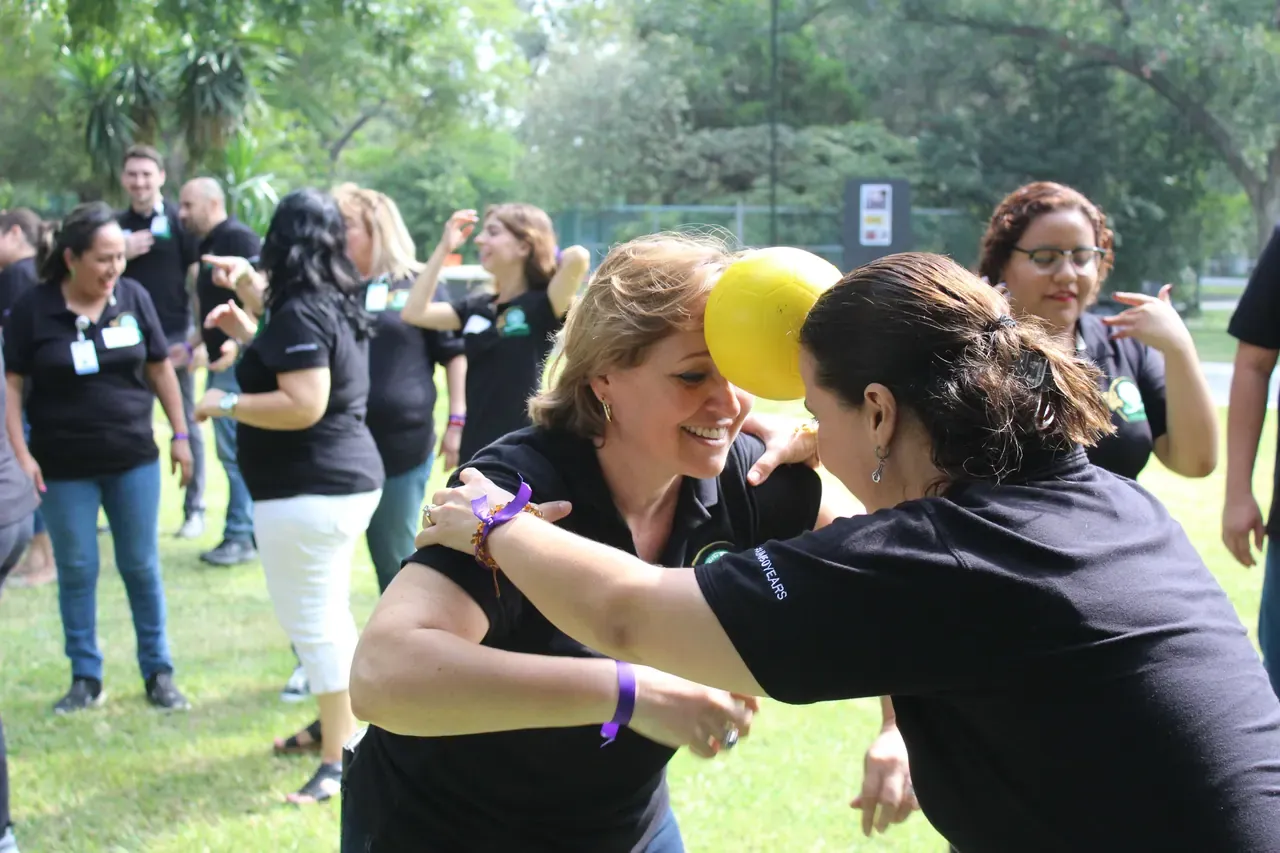 Maestra sonriente durante un reto de equipo, destacando la diversión y la unión logradas durante la integración