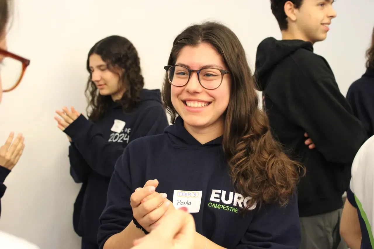 Asistente sonriendo después de una actividad grupal, reflejando el impacto positivo de las pláticas motivacionales