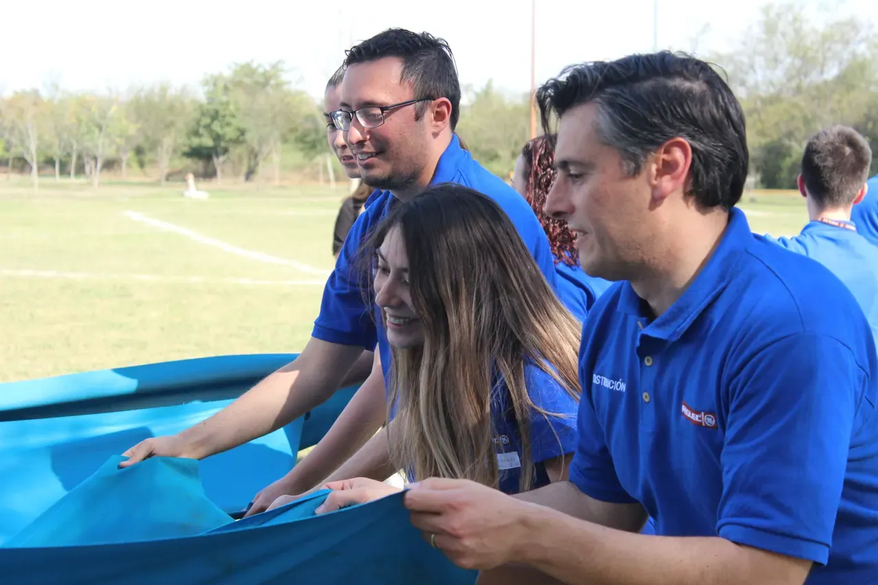 Grupo colaborando para resolver un desafío al aire libre, mostrando el poder de la unión y el trabajo en equipo
