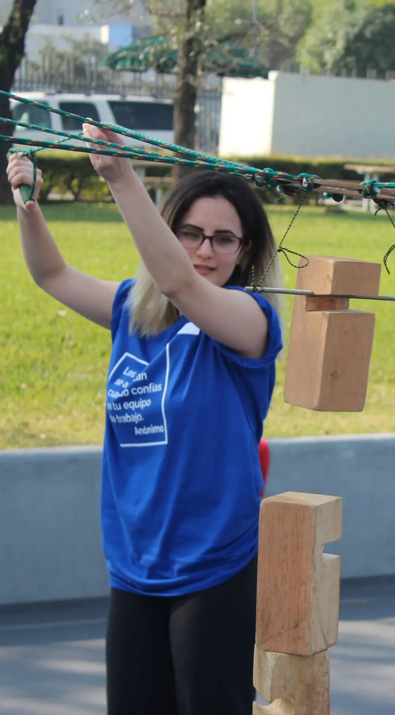 Dinámica al aire libre con participantes superando retos físicos, fomentando la confianza y el trabajo en equipo
