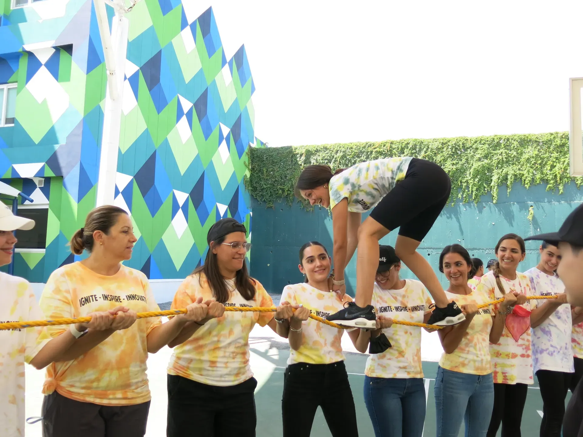 Participantes colaborando en una actividad dinámica al aire libre, fortaleciendo el trabajo en equipo y la confianza